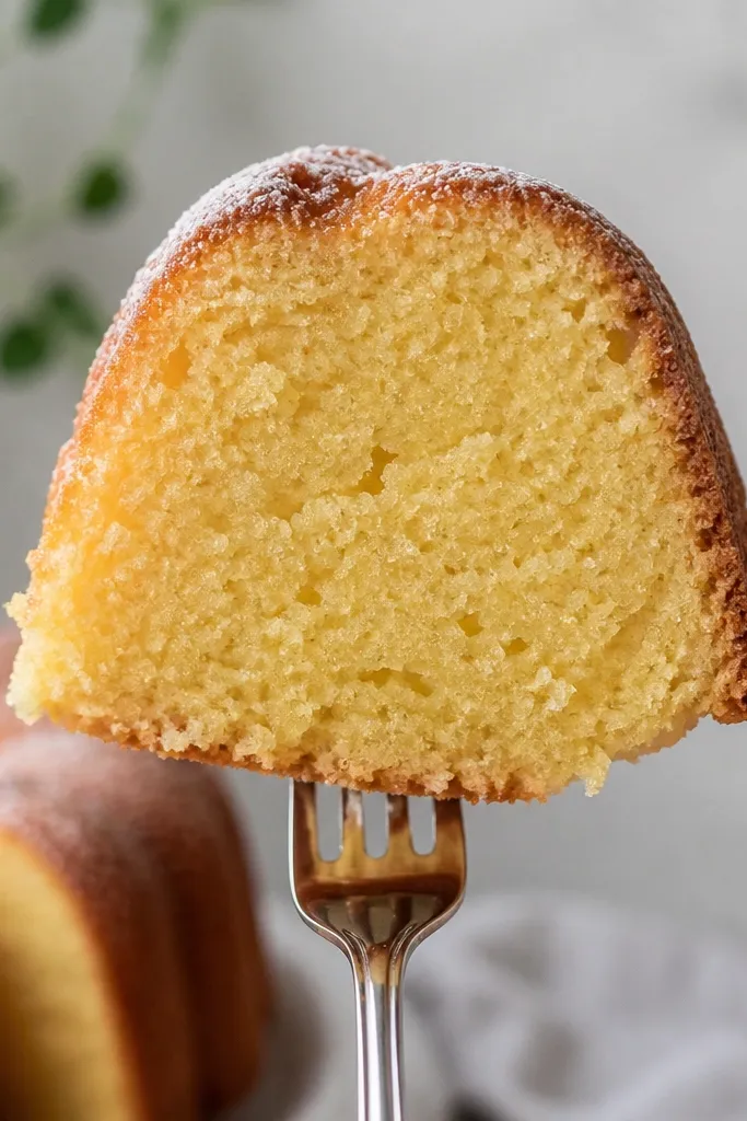 A close-up of a slice held upright with a fork, the crumb doesn't smear, and the interior looks moist but structured.